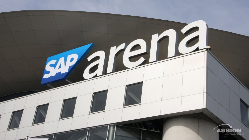 Die Außenansicht der SAP-Arena mit einem großen Schild mit dem SAP-Logo und dem Wort "Arena" an der Fassade des Gebäudes.