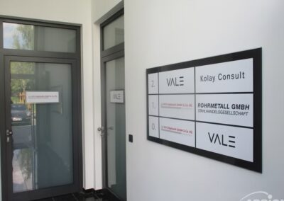 Büroflur mit Glastüren; ein Wandverzeichnis führt Kolay Consult, Rohmetall GmbH und Vale im ersten und zweiten Stock auf.