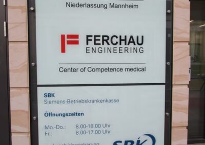 Das Bauschild zeigt die Standorte von Ferchau Engineering und die Öffnungszeiten der SBK Siemens-Betriebskrankenkasse: Mo 8:00-18:00 und Fr 8:00-17:00, sowie nach Vereinbarung.