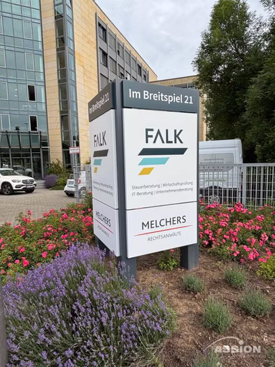 Das Schild des Bürogebäudes Im Breitspiel 21 zeigt die Firmen FALK und MELCHERS mit Kontaktinformationen, umgeben von Lavendelpflanzen und geparkten Fahrzeugen im Hintergrund.